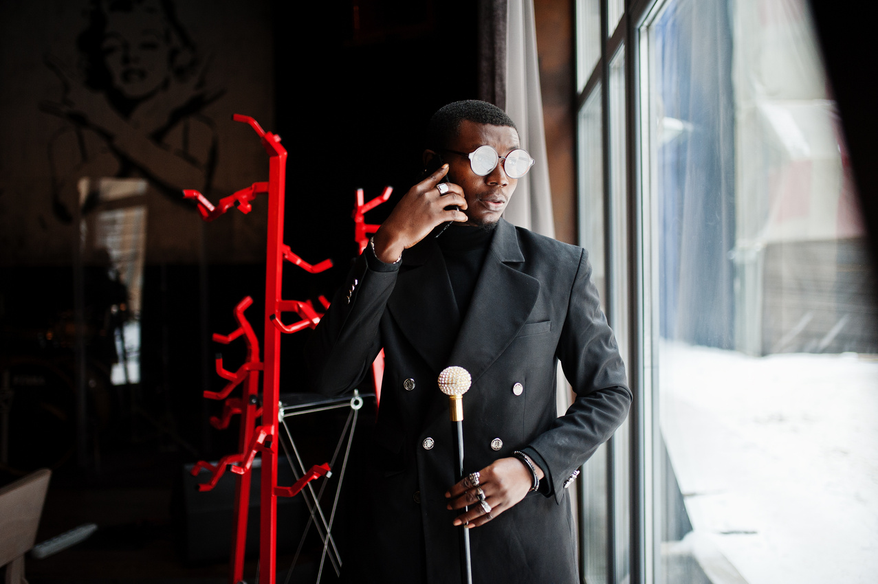 Stylish african american gentleman in elegant black jacket and g